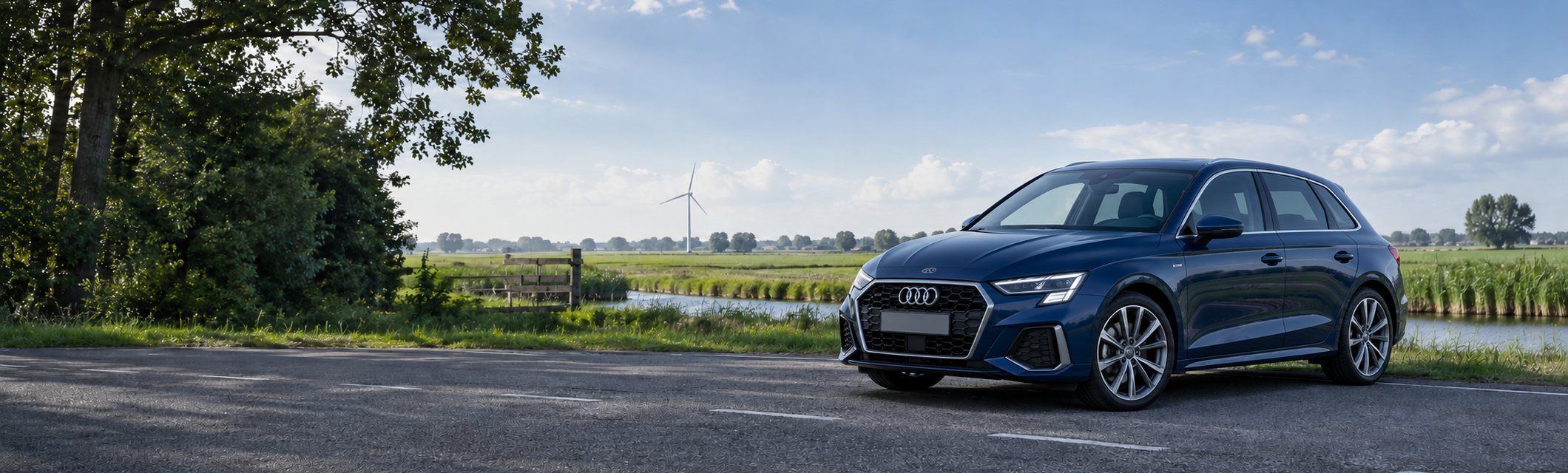 Donkerblauwe Audi A3 Sportback langs een weg in het Nederlandse landschap
